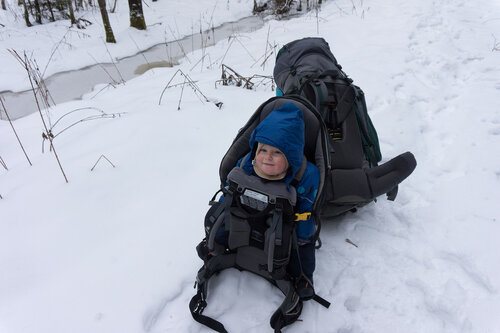 ребенок и рюкзак в пешем зимнем походе